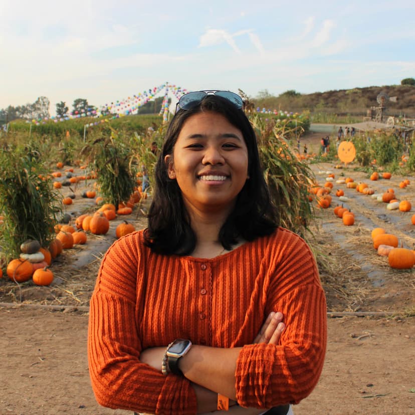 A woman smiling in a pumpkin patch